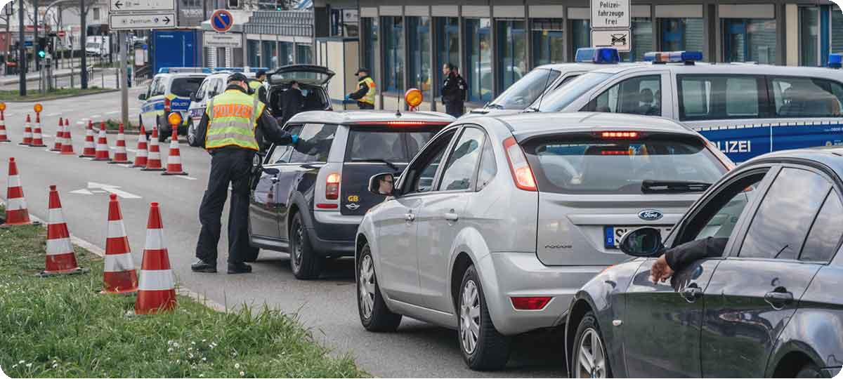 Autos stehen für eine Grenzkontrolle in der Schlange.