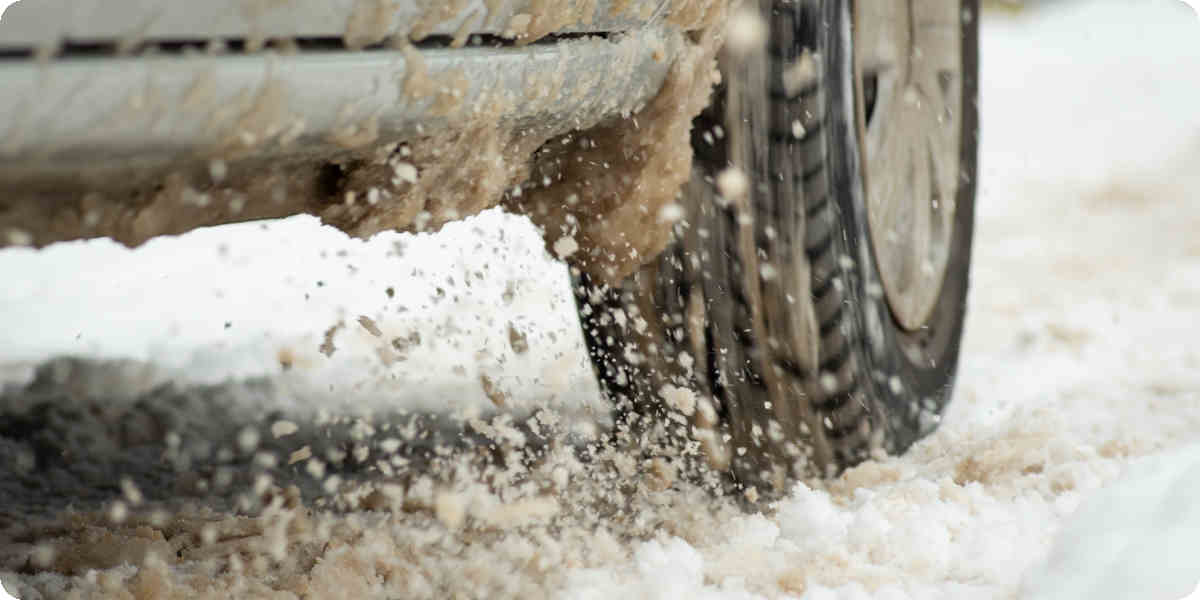 Auto fährt durch Schnee und Matsch.