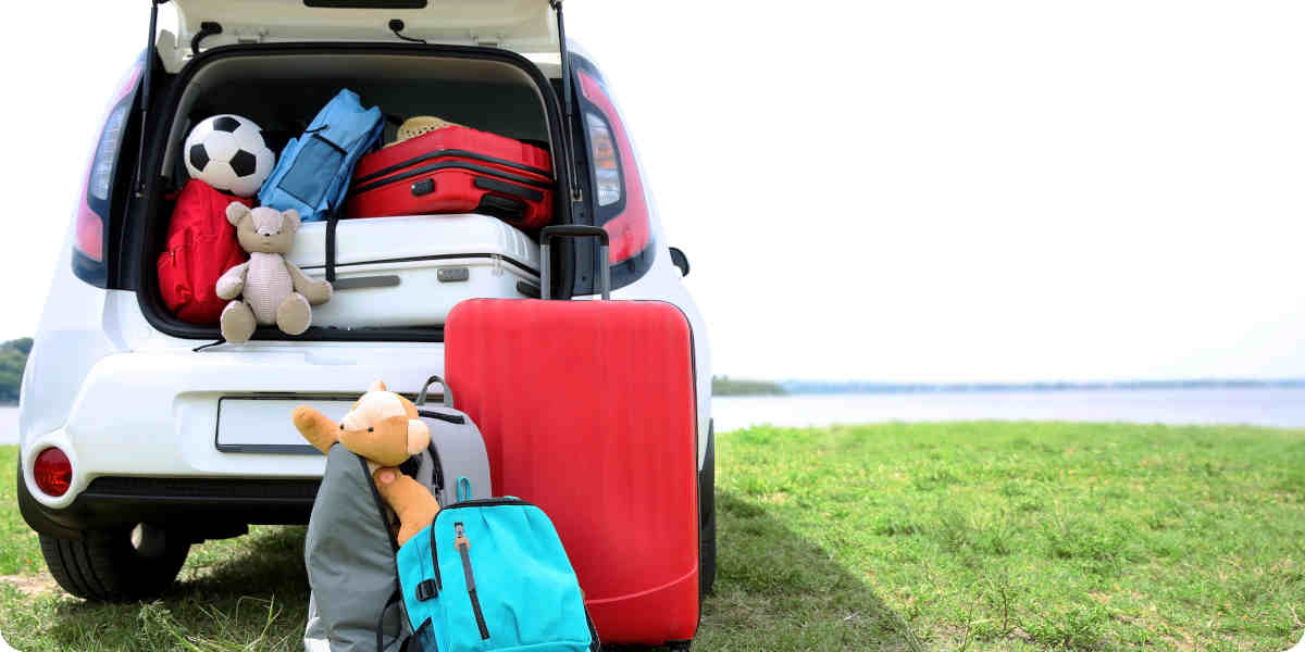 Vollgepackter Kleinwagen auf einer Hügellandschaft.