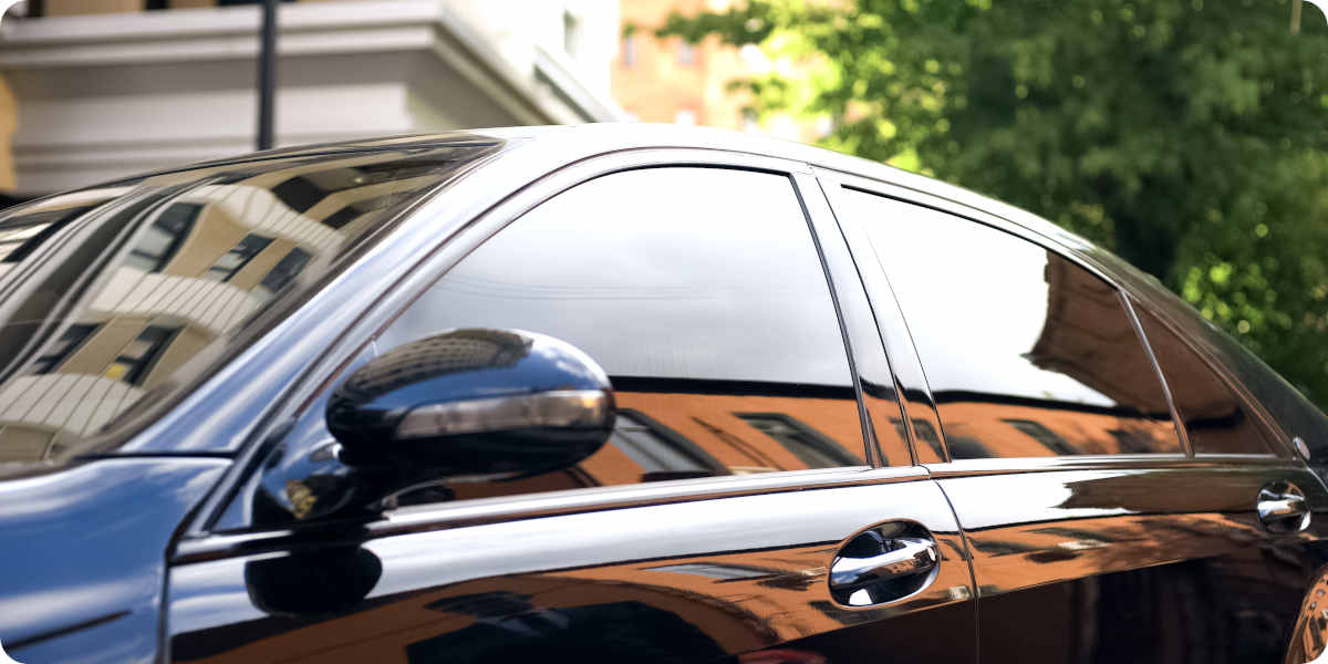 Fotografie einer schwarzen Limousine mit dunkel get&ouml;nten Scheiben.