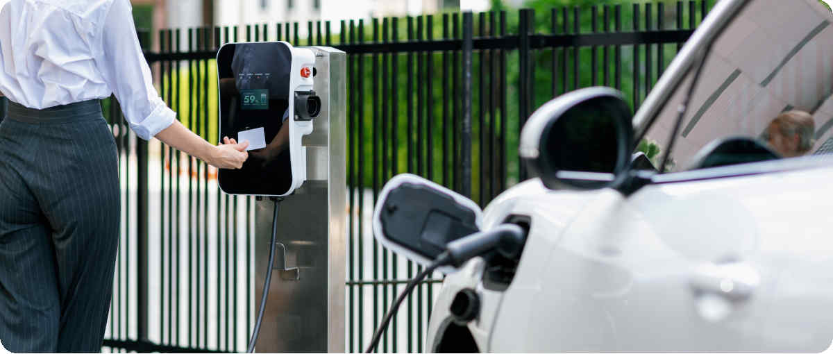 Mann schaltet die Ladestation für sein Elektroauto mit einer Ladekarte frei.