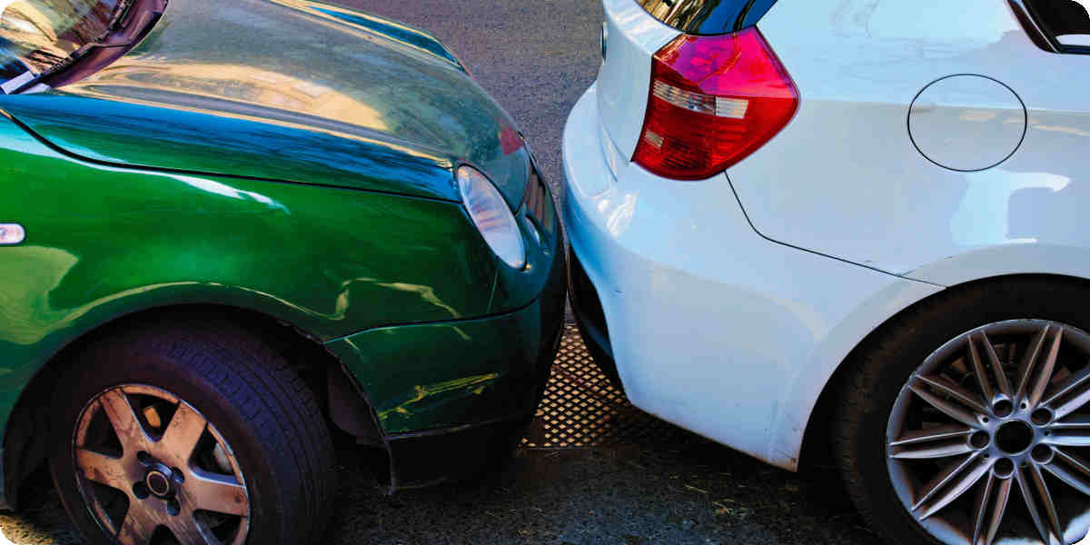 Ein grüner Pkw steht sehr nah am vorausstehenden Fahrzeug.