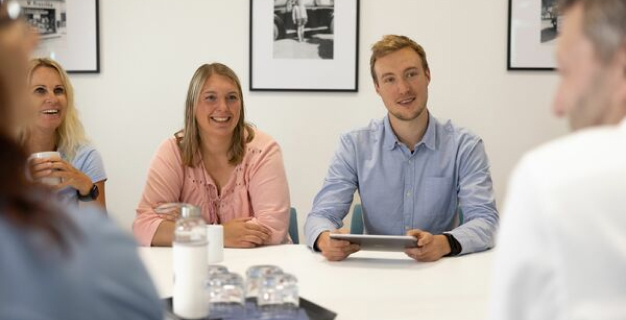 Mitarbeiter von Kroschke sitzen gemeinsam zur Besprechung am Tisch.