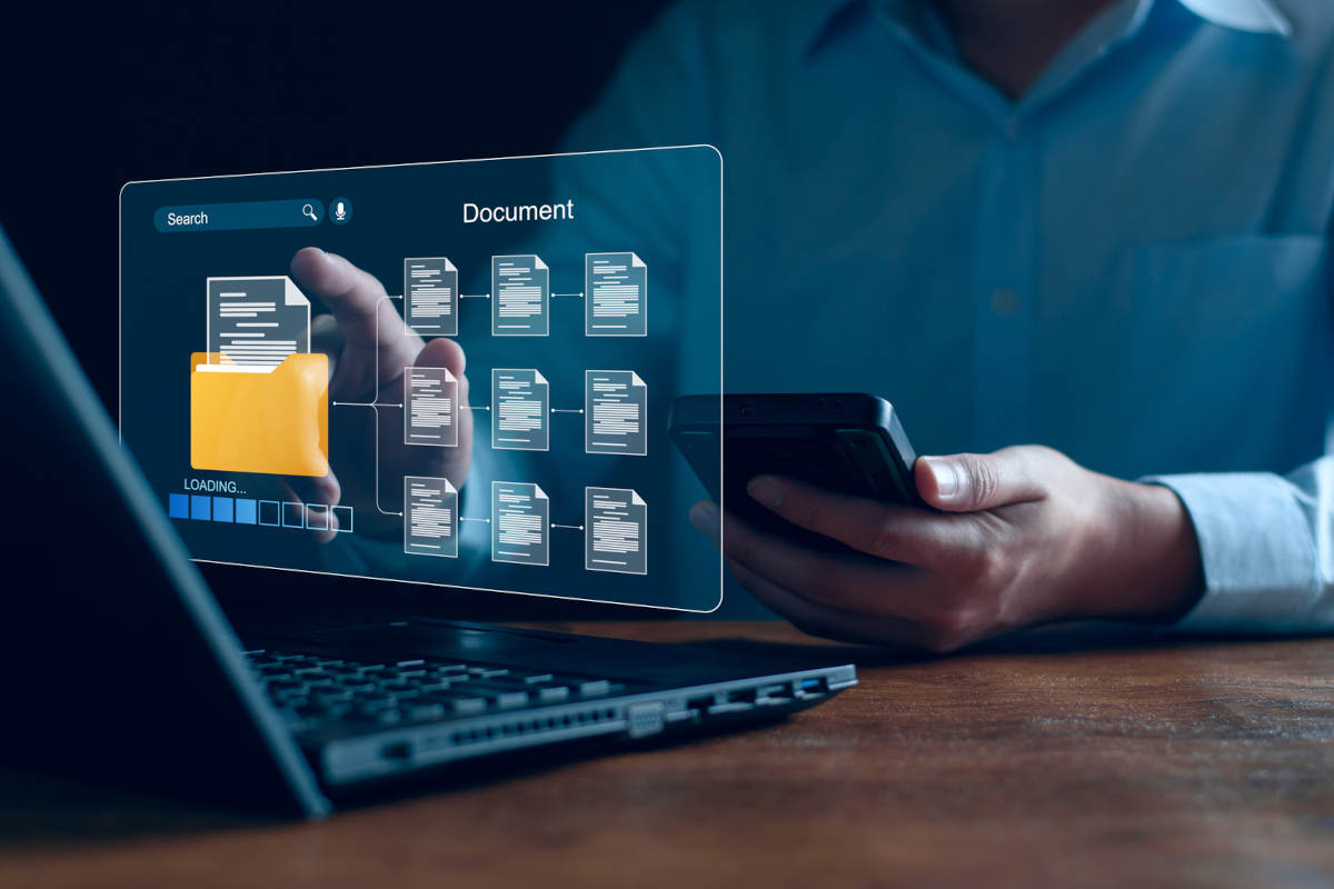 A man works on a laptop with a digital user interface.